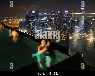 24-02-2017 Marina Bay Sands Singapore - young couple in the infinity pool of marina bay sands hotel in singapore. The pool is famous for its view over Stock Photo