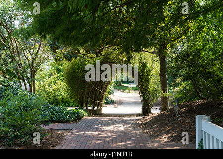 Brick path through arch in the garden Stock Photo