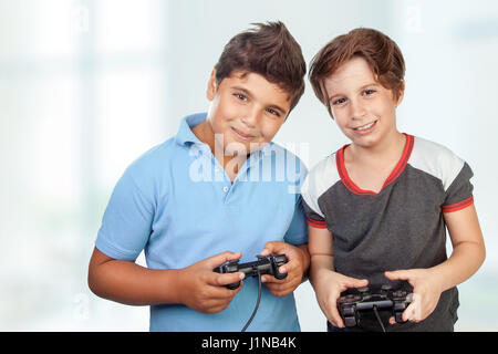 Portrait of a two cute happy boys playing video games at home, best friends enjoying competition on playstation, with pleasure having fun together Stock Photo