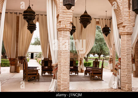 Traditional Moroccan living room. It consists of wooden pieces of furniture covered with a decorated fabric, Arabic shape design. Stock Photo