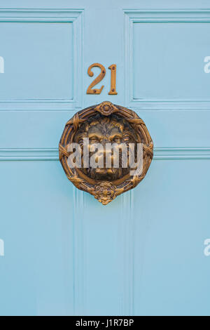 Brass Lions head door knocker and 21 house number on a blue wooden door. Warwick, Warwickshire, England Stock Photo