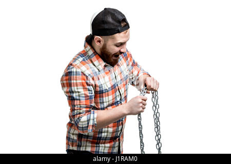 Redhead Bearded man wearing a baseball cap and shirt making streght against a chain. Isolated on white. Stock Photo