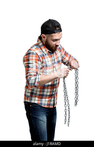Redhead Bearded man wearing a baseball cap and shirt making streght against a chain. . Isolated on white. Stock Photo