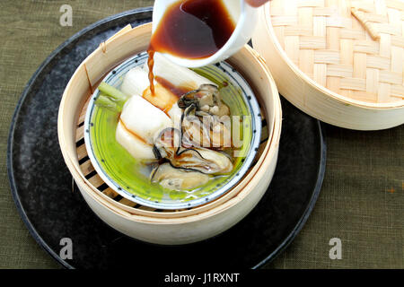 Oyster soup with produce and radish in bamboo tray Stock Photo