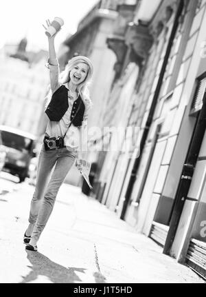 Happy tourist girl with map walking on city street Stock Photo