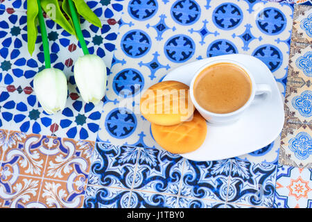 Cup of Arabian Coffee on an Oriental Colorful Background / Cup of Espresso on an Oriental Colorful Background with Flowers, Rings, and Tamr dates Stock Photo