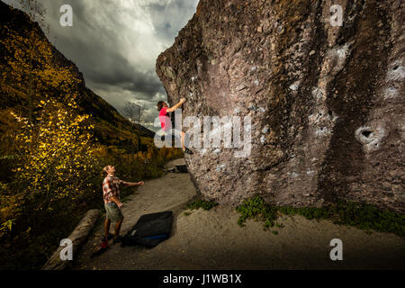 Andrew Merrill spotting Chris Brock bouldering at the Mine boulders near Telluride, CO. Stock Photo