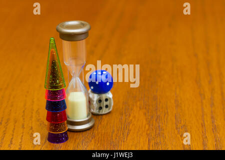 Six colored pawns and two dice isolated on a wooden background macro Stock Photo