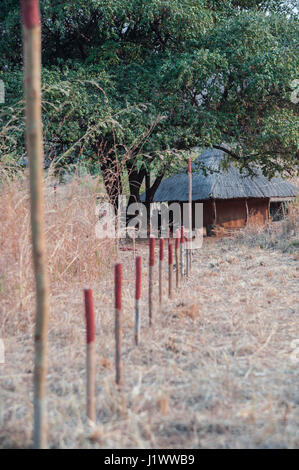 Stakes demarcate a minefield adjacent to a village near Cahora Bassa, Mozambique. The county was declared mine free in 2015 Stock Photo