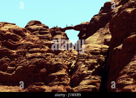 Tourist walking on an natural arch in Wadi Rum protected area in Jordan. Stock Photo