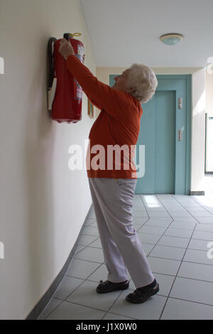 ���ܱ����ö�������� zu hoch montiert: im Ernstfall ein Problem für kleine und ältere Hausbewohner; fire extinguisher too high for smaller or elderly people Stock Photo