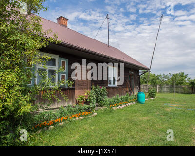 Karpiska, Poland - June 28, 2016: Wooden hut with well-tended garden in the countryside near Warsaw Stock Photo