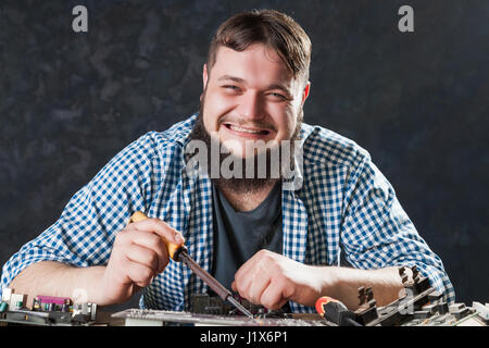 Repairman fixing problem with soldering tool. Engineer repairs computer components with soldering iron. Stock Photo