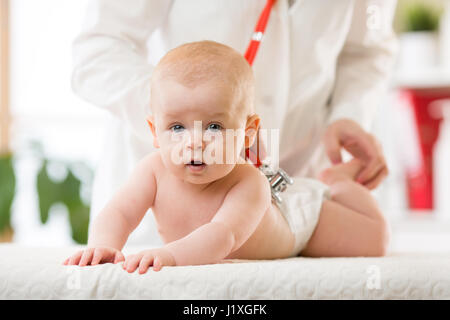 Pediatrician taking care of baby. Little boy is being examine by doctor with stethoscope in hospital. Health care and medicine concept. Stock Photo