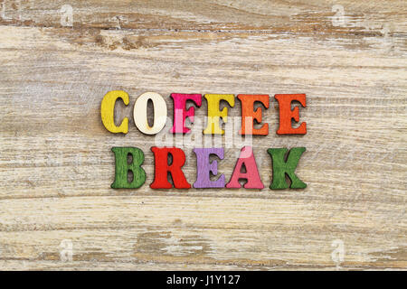 Coffee break written with colorful letters on rustic wooden surface Stock Photo