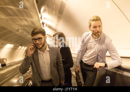 Coworkers using subway stairs together to get underground Stock Photo