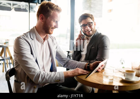 Smart businessman wearing suit using tablet in cafe Stock Photo