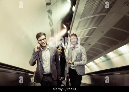 Coworkers using subway stairs together to get underground Stock Photo