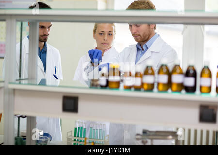 Group of young chemical technicians perform experiment in lab Stock Photo
