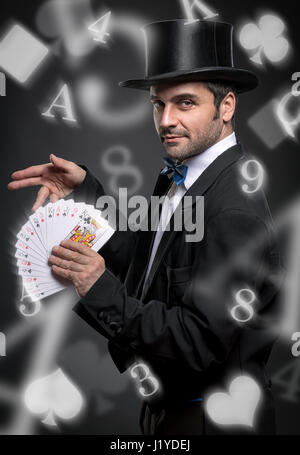 Magician performing trick with playing cards, magic show Stock Photo