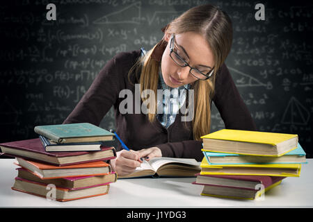 young girl working homework at desk Stock Photo