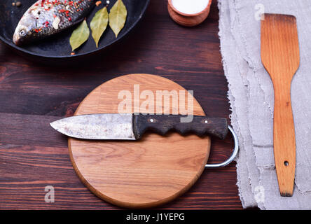 Kitchen knife on a circular cutting wooden board, top view Stock Photo