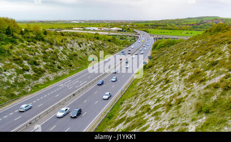 Country road. Cars on the A27 3 lane carriageway through a valley cut through hills in the British countryside in Shoreham, West Sussex, England, UK. Stock Photo
