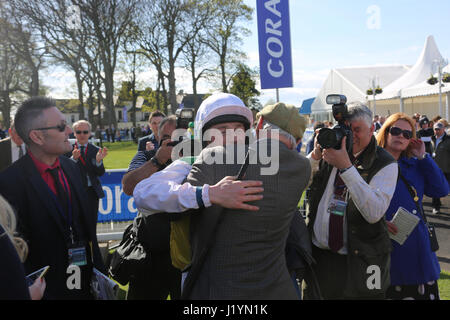 Ayr, Scotland, UK. 22nd April, 2017. Scottish Grand National, Ayr Racecourse. Photo shows jockey Sam Twisten-Davis being congratulated by owner Mr Trevor Hemming Winner Vicente, ridden by jocky Sam Twisten-Davis, owner Mr Trevor Hemming, trainer, Paul Nicolls This is the second win for Vicente, the horse won the Scottish Grand National in 2016 Credit: Alister Firth/Alamy Live News Stock Photo