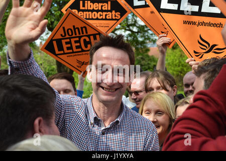Didsbury, UK. 22nd April, 2017. John Leech is greeted and surrounded by crowds of supporters as he arrives in Didsbury to deliver his first campaign rally speech of the 2017 General Election. Leech was the Liberal Democrat MP for Manchester Withington from 2005 until 2015 when he lost to Labour. Leech was elected to Manchester Council in 2016 as the sole opposition, sweeping up 53% of the vote. He is hoping to regain the Withington Parliamentary seat in the 2017 general election. He promised to fight against a hard Brexit, saying Labour and Conservatives had let Manchester down over Brexit. Stock Photo