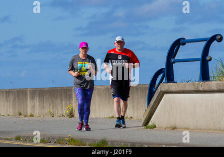 Southport, Merseyside, UK. UK Weather. 23rd April, 2017. Bright sunny but chilly start with temperatures expected to reach double figures in the north west. Early morning activities as residents of the resort and visitors travel on the north-west coast using the cycleway and paths on the seaward side of the promenade. Credit: MediaWorldImages/Alamy Live News Stock Photo