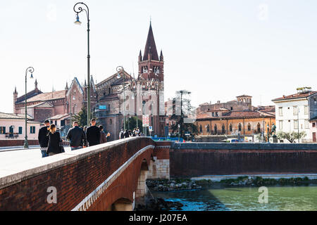 VERONA, ITALY - MARCH 27, 2017: people on bridge Ponte delle Navi and view of Chiesa di San Fermo Maggiore in Verona city. This medieval church hold r Stock Photo