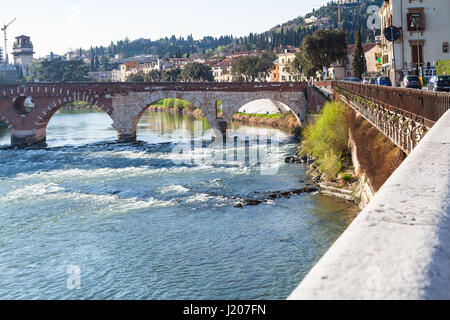 VERONA, ITALY - MARCH 27, 2017: view of Ponte Pietra Roman arch bridge (Stone Bridge, Pons Marmoreus) on Adige River in spring. Verona is city on the  Stock Photo
