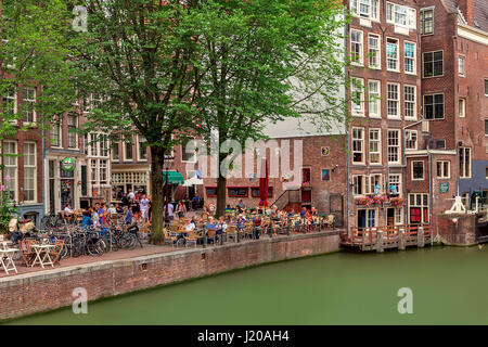 AMSTERDAM, NETHERLANDS - JULY 07, 2015: Outdoor restaurant along canal among old typical buildings in Amsterdam - capital of Netherlands. Stock Photo
