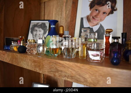 Miniature designer perfume collection displayed with photos in the background Stock Photo