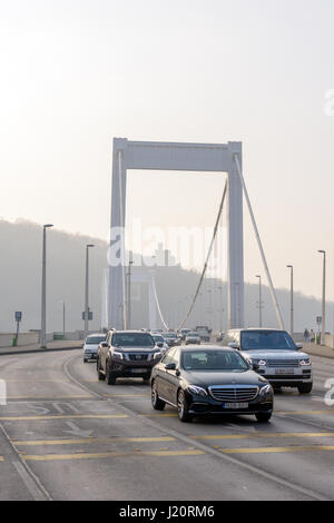 Luxury cars and Elizabeth bridge over Danube river in Budapest, Hungary during a foggy day Stock Photo