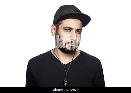 Portrait of young middle eastern man with black t-shirt and cap looking at camera. studio shot, isolated on white background. Stock Photo