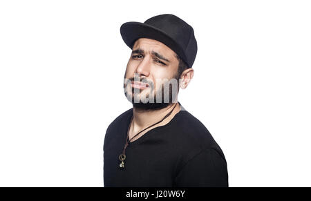 Portrait of young sad unhappy man with black t-shirt and cap looking at camera. studio shot, isolated on white background. Stock Photo
