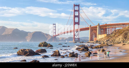 Classic panoramic view of famous Golden Gate Bridge seen from scenic Baker Beach in beautiful golden evening light at sunset, San Francisco, USA Stock Photo