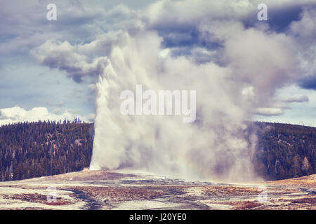 Vintage toned picture of Old Faithful geyser eruption, Yellowstone National Park, Wyoming, USA. Stock Photo