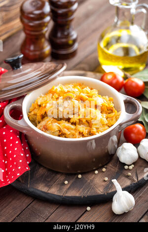 Stewed cabbage with meat on dark rustic wooden background Stock Photo