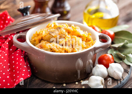 Stewed cabbage with meat on dark rustic wooden background Stock Photo
