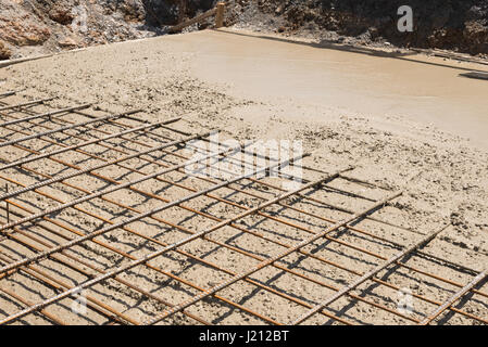 The wet concrete is poured on a steel reinforcement to form strong floor slabs. Stock Photo