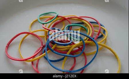 Multicolored rubber bands on white plate close up Stock Photo
