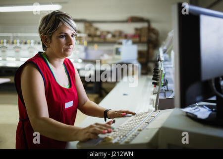 Female employee working on clothing fabric production Stock Photo