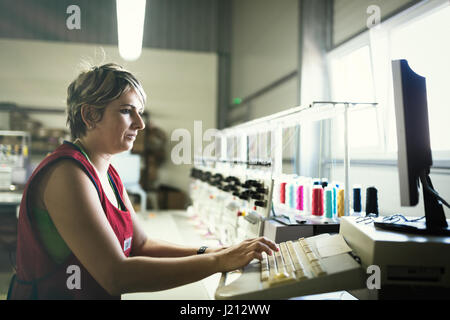 Woman working in computerized fabric industry Stock Photo