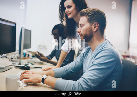 Programmers cooperating at  IT company developing apps Stock Photo
