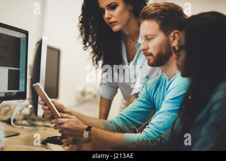 Programmers cooperating at  IT company developing apps Stock Photo