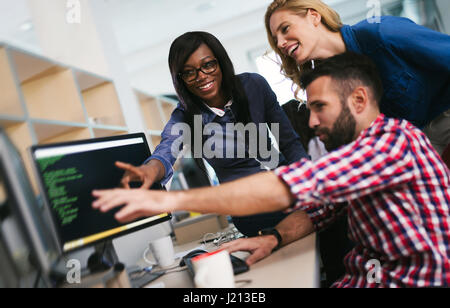 Programmers cooperating at  IT company developing apps Stock Photo