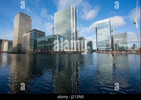 LONDON - NOVEMBER 13, 2016: The modern skyscrapers of Canary Wharf, the city's expanding financial center, stand above the River Thames. Stock Photo
