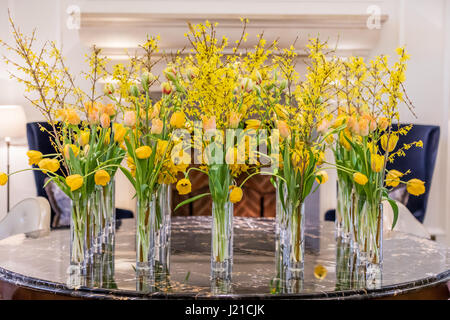 gorgeous yellow flowers in glass vases in a London Hotel lobby Stock Photo